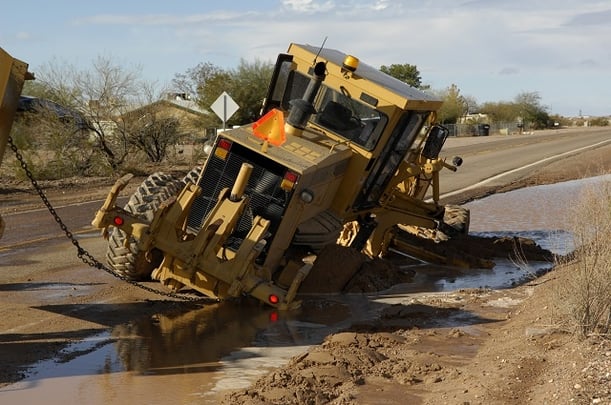 Heavy equipment getting towed out of the mud